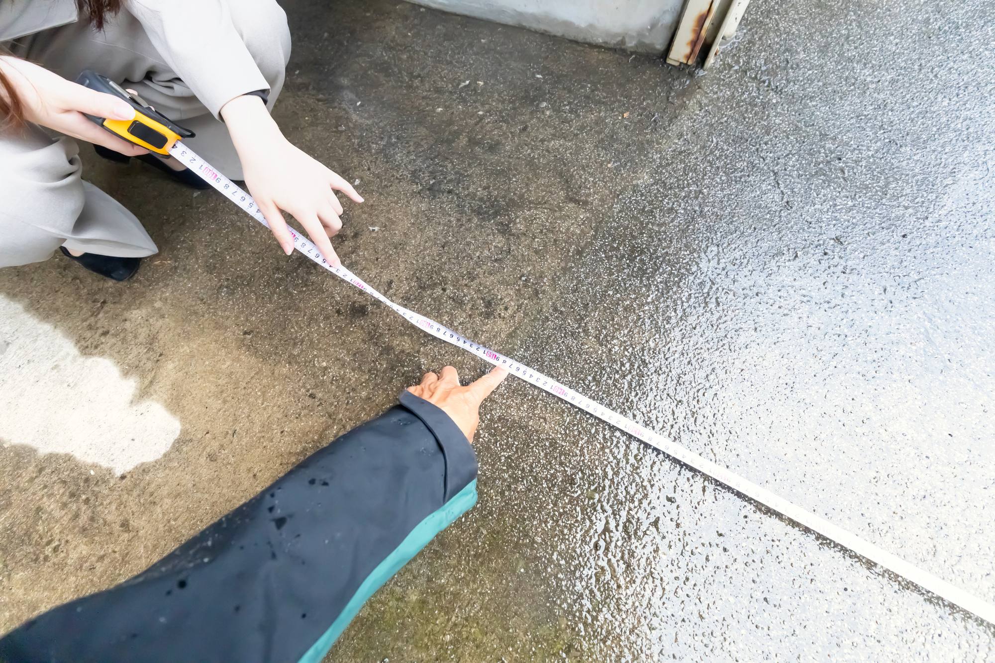 道路の幅をメジャーで測る手元