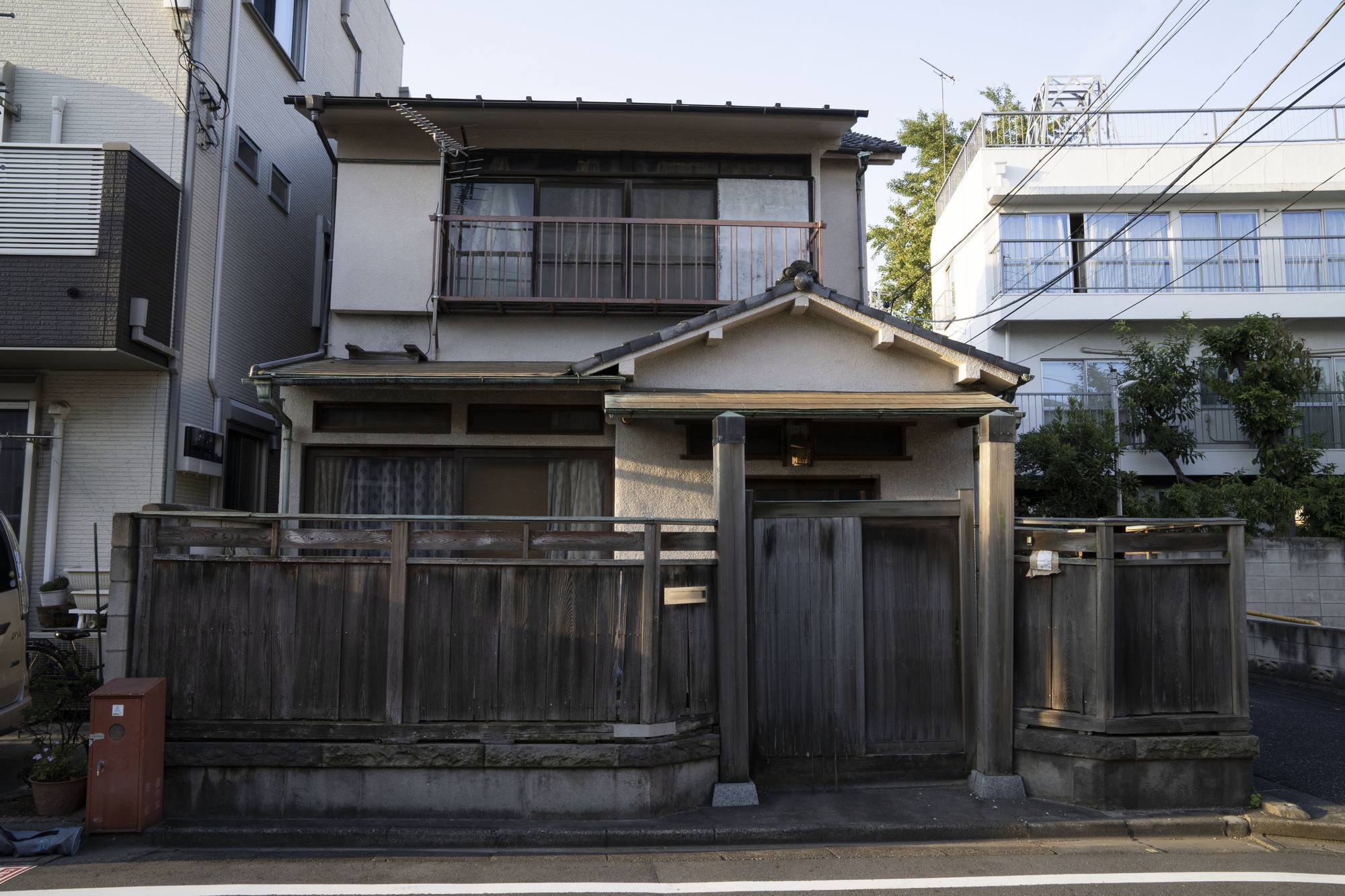 板塀の木造家屋と、隣に建つ新しい建物