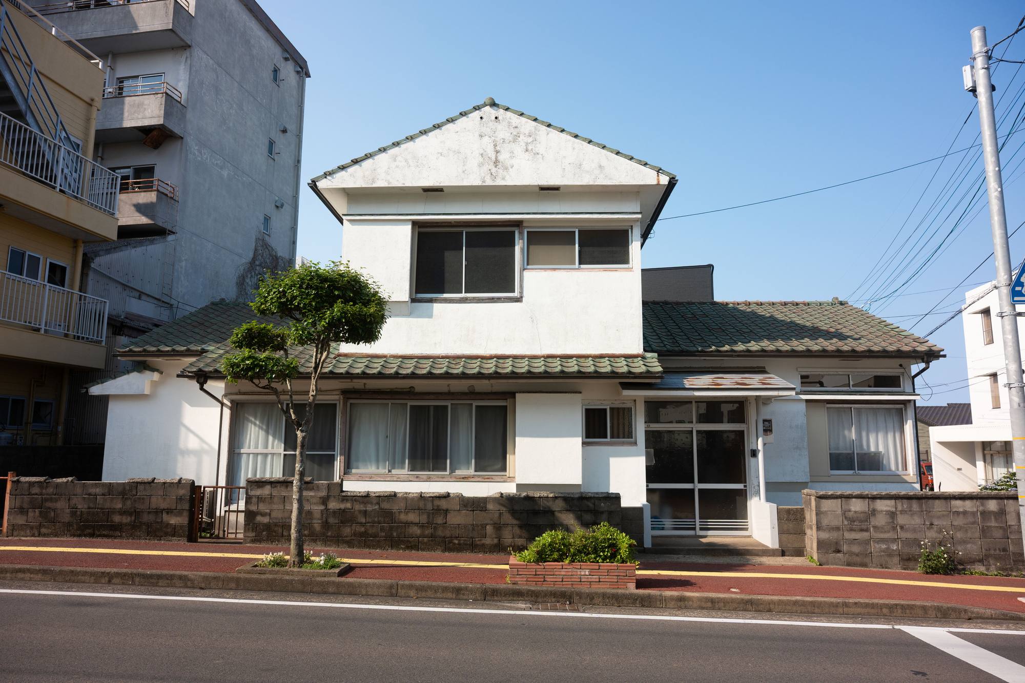 白い外壁と瓦屋根の二階建ての住まい